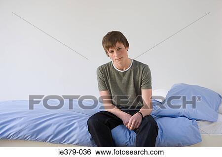 Portrait of a teenage boy sat on his bed View Large Photo Image Stock Photograph - Portrait of a teenage boy sat on his bed. Fotosearch