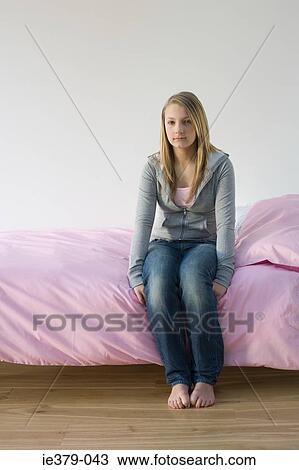 Portrait of a teenage girl sat on a bed View Large Photo Image Stock Image - Portrait of a teenage girl sat on a bed. Fotosearch