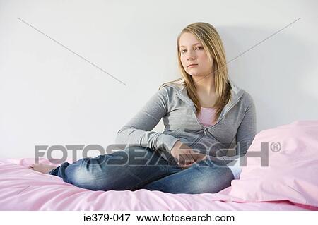 Portrait of a teenage girl sat on a bed View Large Photo Image Stock Photo - Portrait of a teenage girl sat on a bed. Fotosearch