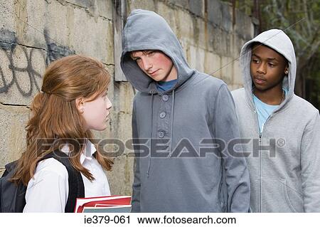 Teenage boys intimidating a teenage girl View Large Photo Image Stock Image - Teenage boys intimidating a teenage girl. Fotosearch