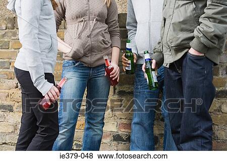 Teenagers holding bottles of alcohol View Large Photo Image Stock Photo - Teenagers holding bottles of alcohol. Fotosearch