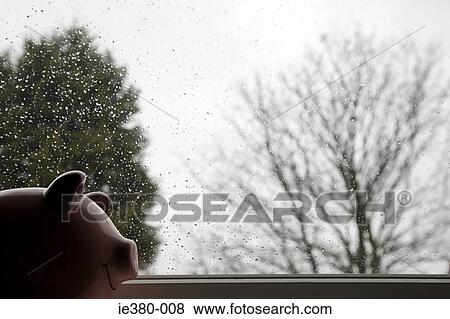 Stock Photo - Piggy bank by rain covered window. Fotosearch