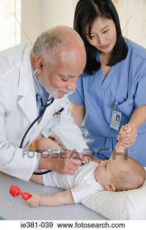 Stock Photo - A doctor and nurse examining a baby. Fotosearch