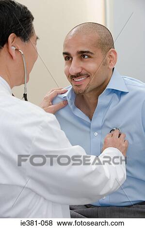 Stock Photo - A doctor examining a patient. Fotosearch