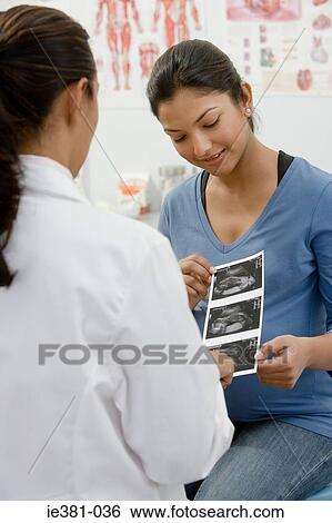 A doctor handing a patient a scan View Large Photo Image Stock Photograph - A doctor handing a patient a scan. Fotosearch