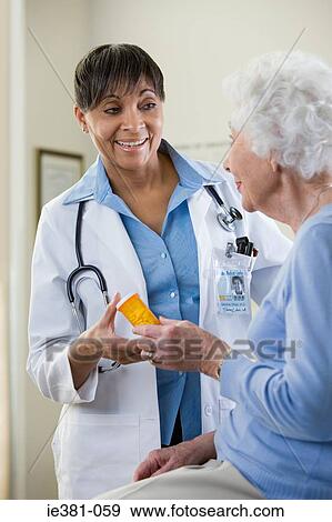 A doctor handing a patient tablets View Large Photo Image Stock Photo - A doctor handing a patient tablets. Fotosearch