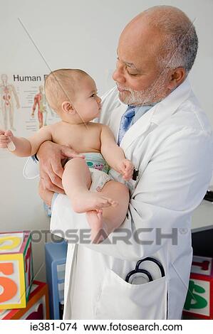 A doctor holding a baby View Large Photo Image Picture - A doctor holding a baby. Fotosearch