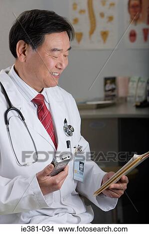 A doctor talking into a taper recorder View Large Photo Image Picture - A doctor talking into a taper recorder. Fotosearch