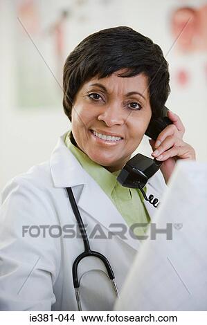 Picture - A doctor using a phone. Fotosearch