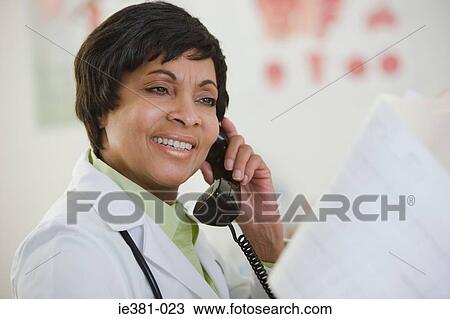 A doctor using a phone View Large Photo Image Stock Image - A doctor using a phone. Fotosearch