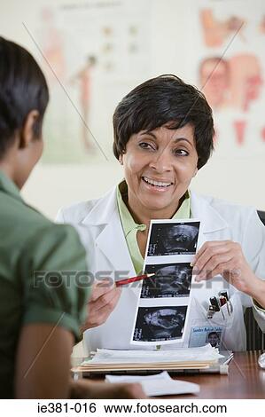 A doctor with a patient holding a scan View Large Photo Image Stock Photograph - A doctor with a patient holding a scan. Fotosearch