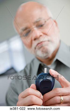 A man doing a home blood glucose testing View Large Photo Image Stock Image - A man doing a home blood glucose testing . Fotosearch