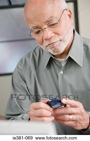 A man doing a home blood glucose testing View Large Photo Image Stock Photo - A man doing a home blood glucose testing . Fotosearch