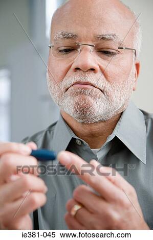 A man doing a home blood glucose testing View Large Photo Image Stock Photography - A man doing a home blood glucose testing . Fotosearch