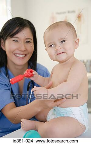 A nurse and examining a baby View Large Photo Image Picture - A nurse and examining a baby. Fotosearch