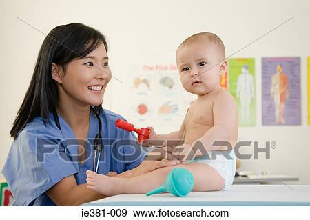 A nurse and examining a baby View Large Photo Image Stock Photo - A nurse and examining a baby. Fotosearch