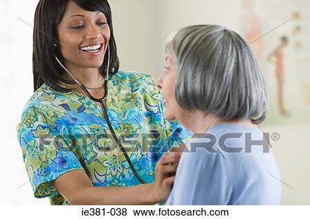 A nurse examining a patient View Large Photo Image Stock Photo - A nurse examining a patient. Fotosearch