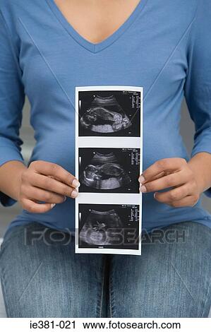 A pregnant woman holding a scan View Large Photo Image Stock Image - A pregnant woman holding a scan. Fotosearch