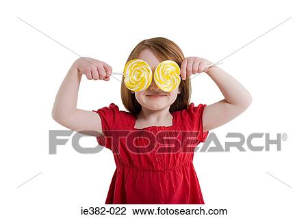 A girl covering her eyes with lollipops View Large Photo Image Stock Image - A girl covering her eyes with lollipops. Fotosearch