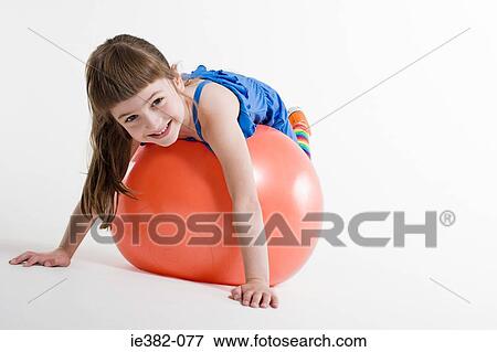 A girl lying on a ball View Large Photo Image Stock Photo - A girl lying on a ball. Fotosearch