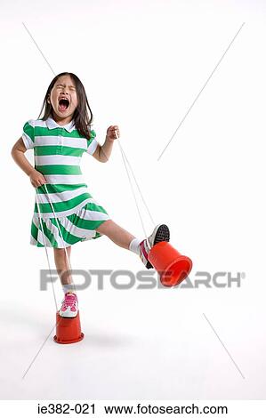 Stock Image - A girl using stilts. Fotosearch