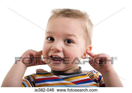 A toddler with his fingers in his ears View Large Photo Image Stock Photograph - A toddler with his fingers in his ears. Fotosearch