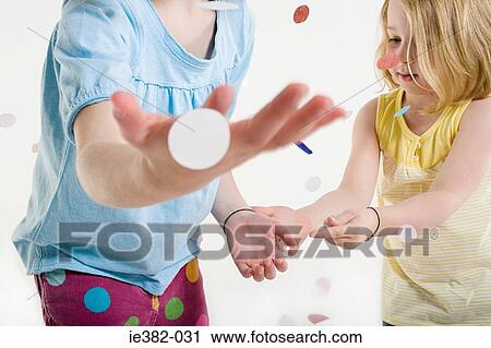Two girls playing in confetti View Large Photo Image Stock Image - Two girls playing in confetti. Fotosearch