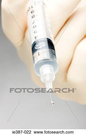 A doctor holding a syringe View Large Photo Image Stock Image - A doctor holding a syringe. Fotosearch