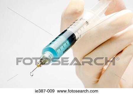 A doctor holding a syringe View Large Photo Image Stock Photo - A doctor holding a syringe. Fotosearch
