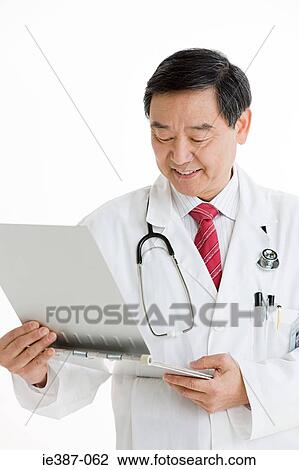 A doctor looking at a chart View Large Photo Image Stock Image - A doctor looking at a chart. Fotosearch
