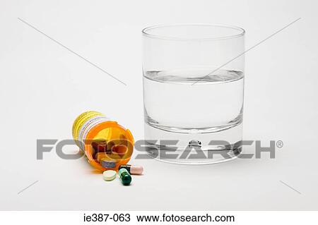 Stock Image - Tablets and a glass of water. Fotosearch