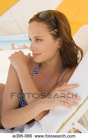 A woman on a lounge chair View Large Photo Image Stock Photograph - A woman on a lounge chair. Fotosearch