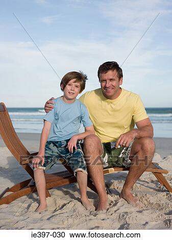 Father and son on lounge chair View Large Photo Image Stock Image - Father and son on lounge chair. Fotosearch