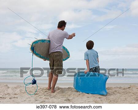 Stock Photo - Father and son with surfboard and bodyboard. Fotosearch