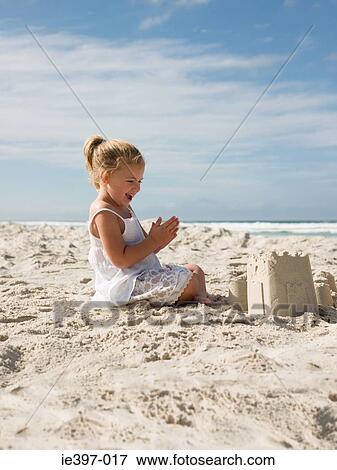 Happy girl with sandcastle View Large Photo Image Stock Photo - Happy girl with sandcastle. Fotosearch
