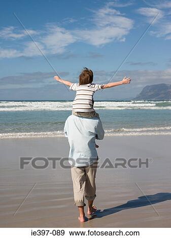 Man carrying son by sea View Large Photo Image Stock Photo - Man carrying son by sea. Fotosearch