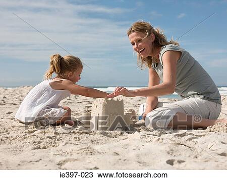 Mother and daughter making sandcastles View Large Photo Image Stock Image - Mother and daughter making sandcastles. Fotosearch