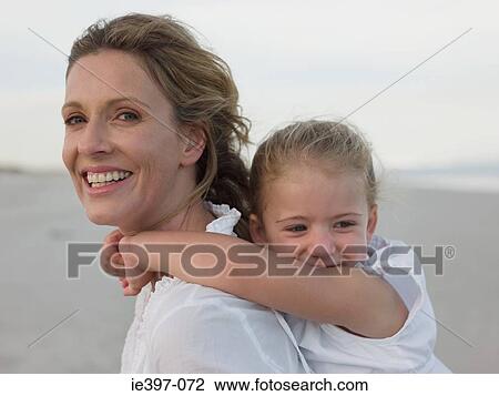 Stock Image - Mother giving daughter piggyback. Fotosearch