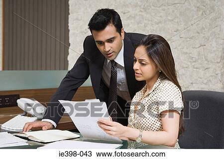 Stock Image - Business colleagues reading a document. Fotosearch