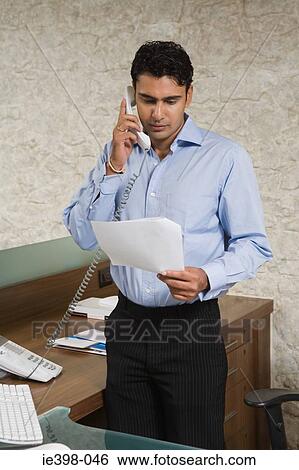 Businessman reading a document View Large Photo Image Stock Photograph - Businessman reading a document. Fotosearch