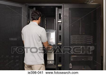 Computer technician working on a server View Large Photo Image Stock Image - Computer technician working on a server. Fotosearch