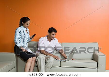 Couple using wireless technology at home View Large Photo Image Picture - Couple using wireless technology at home. Fotosearch