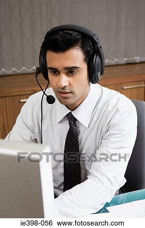 Indian man working in a call centre View Large Photo Image Stock Photograph - Indian man working in a call centre. Fotosearch