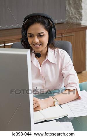 Picture - Indian woman wearing a telephone headset. Fotosearch