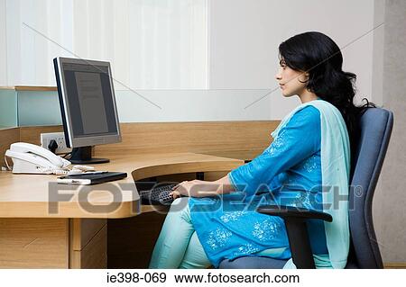 Indian woman working at her desk View Large Photo Image Stock Photo - Indian woman working at her desk. Fotosearch