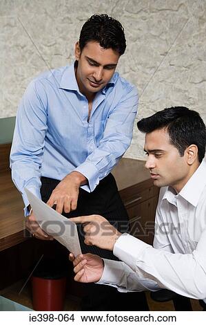 Male office colleagues reading a document View Large Photo Image Picture - Male office colleagues reading a document. Fotosearch