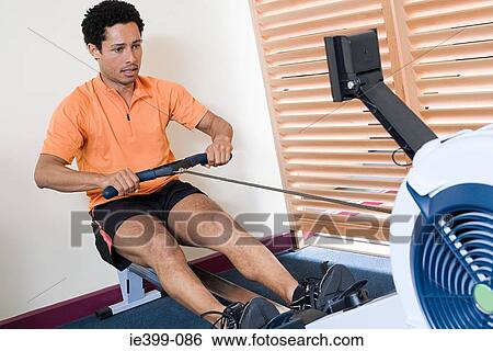 Man on rowing machine View Large Photo Image Stock Photograph - Man on rowing machine. Fotosearch