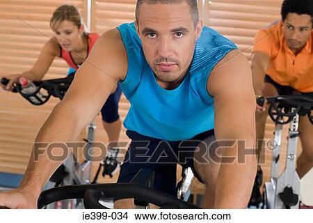 Picture - People on exercise bikes. Fotosearch