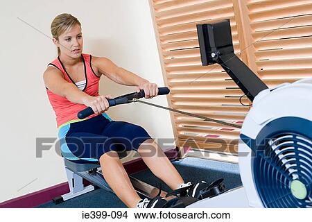 Woman on rowing machine View Large Photo Image Picture - Woman on rowing machine. Fotosearch