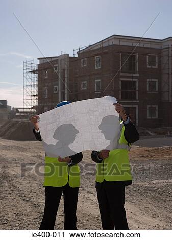 Stock Image - Architects with blueprint. Fotosearch